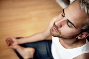 man with eyes closed doing yoga