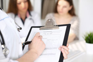 Patient and doctor with clipboard preparing for treatment