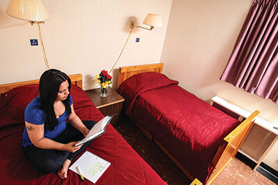 a young woman on a bed reading a notepad