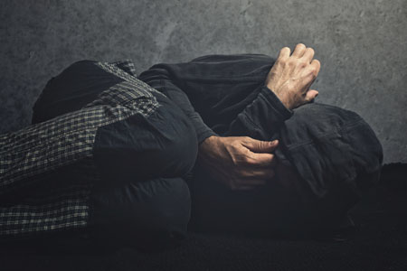 A man curling up in a corner